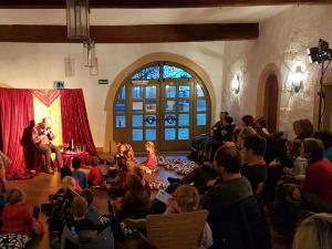 Märchenerzähler erzählt in einer Bibliothek Kindern und Erwachsenen